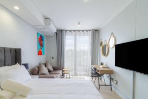une chambre avec un lit, un canapé et une télévision dans l'établissement Ellipse Waterfall 4212, à Midrand 25 autres photos