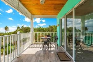 eine Veranda mit einem Tisch und Stühlen darauf in der Unterkunft The Starfish at Cottages in Sand Bluff