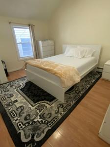 a bedroom with a white bed on a rug at private room in Paterson