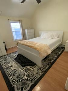 a bedroom with a white bed and a rug at private room in Paterson