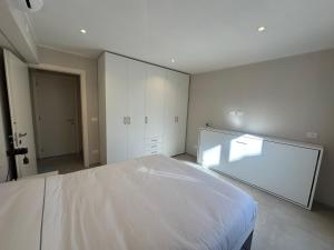 a bedroom with a white bed and a glass wall at Casa PORTA LANERO di Francesco e Alessandro in Nizza Monferrato