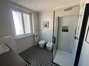 a bathroom with a toilet and a glass shower at Casa PORTA LANERO di Francesco e Alessandro in Nizza Monferrato