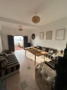 een woonkamer met een tafel en een bank bij Unique villa legzira in Mirleft