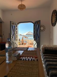 a room with a table with a view of the ocean at À Unique villa, 4 rooms, 5 beds , entire house, LEGZIRA Beach in Sidi Ifni