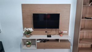 a living room with a tv on a wall at Kitnet Muriqui 1 in Mangaratiba