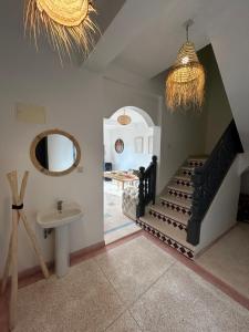 een kamer met een trap, een wastafel en een spiegel bij Unique villa legzira in Mirleft