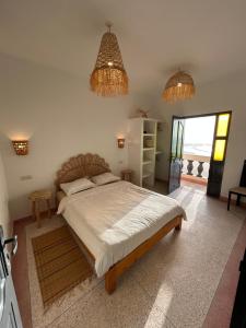 a bedroom with a large bed and two chandeliers at À Unique villa, 4 rooms, 5 beds , entire house, LEGZIRA Beach in Sidi Ifni