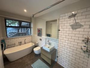 een badkamer met een bad, een wastafel en een toilet bij Reef House in Ballito +19 foto's