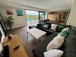 een woonkamer met een bank en een tafel bij Reef House in Ballito