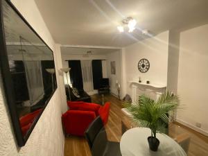 ein Wohnzimmer mit einem roten Stuhl und einem Tisch in der Unterkunft meadow house close to city center in Belfast