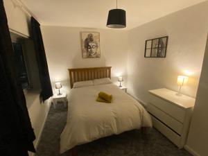 ein Schlafzimmer mit einem Bett mit einem gelben Kissen darauf in der Unterkunft meadow house close to city center in Belfast