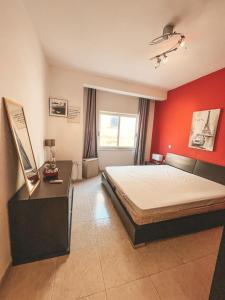 a bedroom with a bed and a red wall at Panoramic Sea Views 3 Bedroom Apartment in St Julians in St Julian's