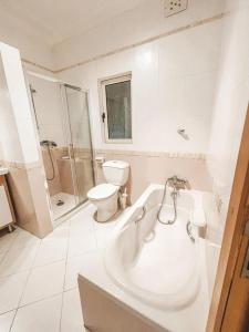 a white bathroom with a tub and a toilet at Panoramic Sea Views 3 Bedroom Apartment in St Julians in St Julian's +21 photos