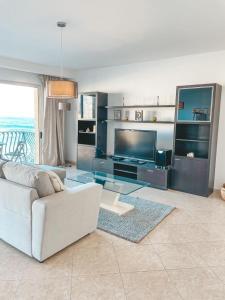 a living room with a white couch and a television at Panoramic Sea Views 3 Bedroom Apartment in St Julians in St Julian's