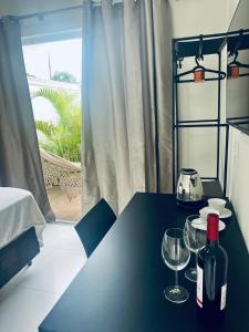 una mesa con dos copas y una botella de vino en MarisC&LHouse 1- Quarto casal, en Bombinhas 17 fotos más