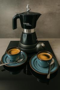 a coffee maker and two cups of coffee on a table at Apartmán Sivý vlk Hrebienok Rezort in Smokovce