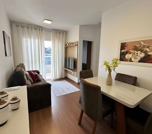 uma cozinha e sala de estar com uma mesa e um sofá em Plano 22 Prime Loft em Extrema