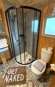 ein Bad mit Dusche mit WC und ein Schild in der Unterkunft Keepers Cottage in Ipswich