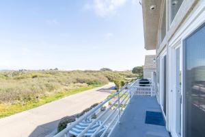 a balcony of a house with blue benches on it at Oceano Lagoon in Oceano