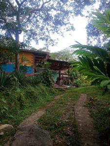 a house with a dirt road in front of it at Casa Refugio LA TEBAIDA in Mocoa