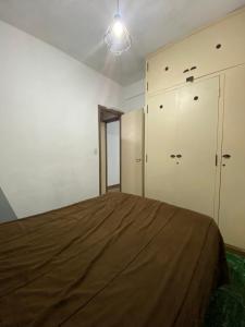 een slaapkamer met een bed en 2 kasten bij Departamento 2 ambientes en MIRAMAR in Miramar +4 foto's
