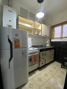 een keuken met een koelkast en een fornuis bij Departamento 2 ambientes en MIRAMAR in Miramar