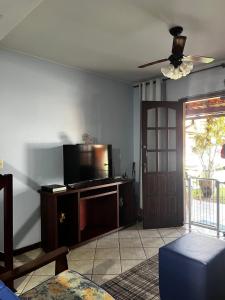 een woonkamer met een flatscreen-tv en een deur bij Casa Duplex com 02 suites completa em Condomínio com Piscina , Sauna , churrasqueiras, deck podendo parar embarcações, próximo as Praias das Conchas e Peró e também linda Ilha do Japônes in Cabo Frio