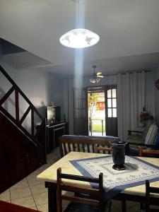 een keuken en eetkamer met een tafel en een licht bij Casa Duplex com 02 suites completa em Condomínio com Piscina , Sauna , churrasqueiras, deck podendo parar embarcações, próximo as Praias das Conchas e Peró e também linda Ilha do Japônes in Cabo Frio +29 foto's