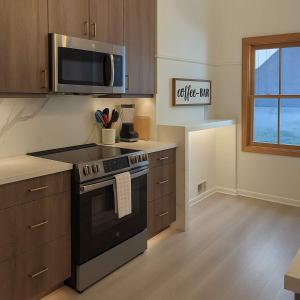a kitchen with a stove and a microwave at The Hillside - Historic Tudor retreat in SLC in Garden Towers Condominium