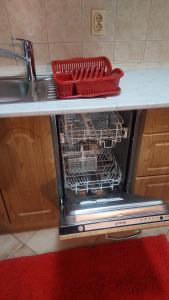 a dishwasher with a red basket on top of it at Lux apartman sa garažom in Banja Luka