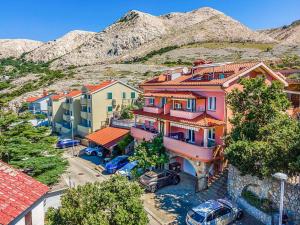 a group of buildings with cars parked in a parking lot at Apartments in Stara Baska - Insel Krk 34433 in Stara Baška