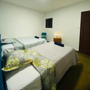 Habitación con 2 camas y mesa con TV. en Hostal La casa de Ross, en Santa Ana 10 fotos más