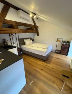 een slaapkamer met een bed in een kamer met houten vloeren bij Altstadt Apartments 27 in Beilngries