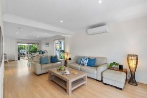 ein Wohnzimmer mit zwei Sofas und einem Couchtisch in der Unterkunft Scribbly Gums Callala Beach in Callala Beach