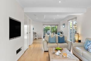 ein Wohnzimmer mit Sofa und Tisch in der Unterkunft Scribbly Gums Callala Beach in Callala Beach