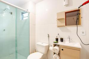 a bathroom with a toilet and a glass shower at Suíte na Flor de Debora in Alto Paraíso de Goiás