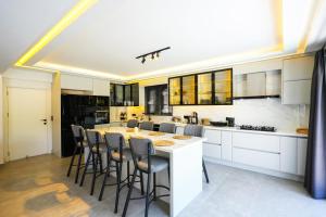een keuken met een groot eiland met barkrukken bij Dalyan Villa Oliva in Dalyan