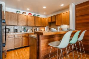 a kitchen with wooden cabinets and bar stools at Cedar and Snow in Mammoth Lakes