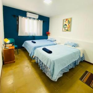 Dos camas en una habitación con paredes azules. en Hostal La casa de Ross, en Santa Ana