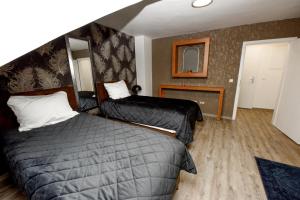 ein Hotelzimmer mit zwei Betten und einem Spiegel in der Unterkunft Haus Thomas Deluxe 4 in Dortmund