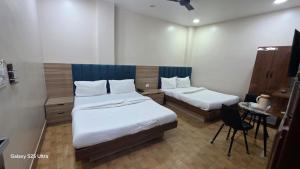 a room with two beds and a table and a chair at fab THE MALEEN New Delhi in New Delhi