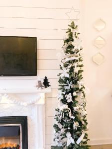 un árbol de Navidad en una sala de estar con chimenea en Chic flat close to Edinburgh, Airport, & Zoo, en Edimburgo