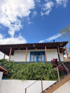 a white house with a wooden roof at Casa Quintal Sebollas - Paraíba do Sul in Paraíba do Sul