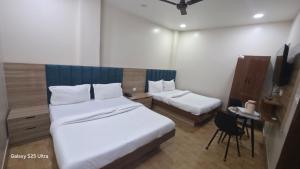 a hotel room with two beds and a chair at fab THE MALEEN New Delhi in New Delhi