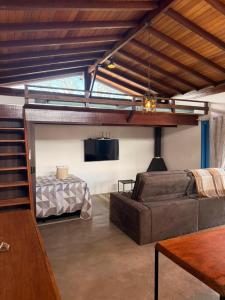 a living room with a couch and a bed at Casa Quintal Sebollas - Paraíba do Sul in Paraíba do Sul