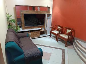 Una sala de estar con un sofá y un televisor de pantalla plana. en barbershopcavalheiro, en Belém