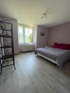 a bedroom with a bed with red pillows at Maison Lac de Chalain - Jura in Fontenu