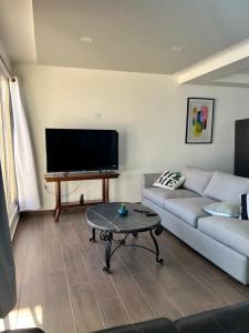 a living room with a couch and a flat screen tv at Beach house oceacn front Rosarito in Rosarito