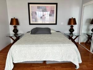 a bedroom with a bed with two lamps and a picture at Beach house oceacn front Rosarito in Rosarito +12 photos