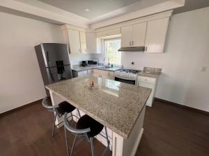 a kitchen with a granite counter top and a refrigerator at Beach house oceacn front Rosarito in Rosarito